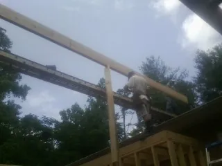 Carpenter setting a ridge beam over a new addition frame — Ice Dam Removal by Roofing Brothers in Lutherville Timonium