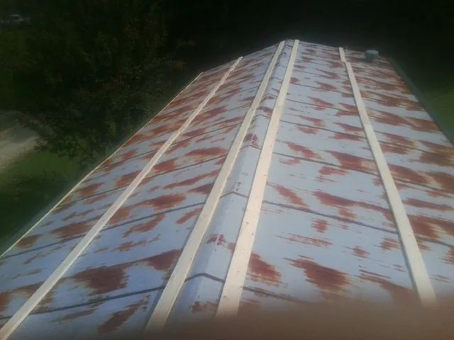 Rusted metal roof panels with new wood purlins before replacement — Storm Damage Roof Repair in Lutherville Timonium by Roofing Brothers