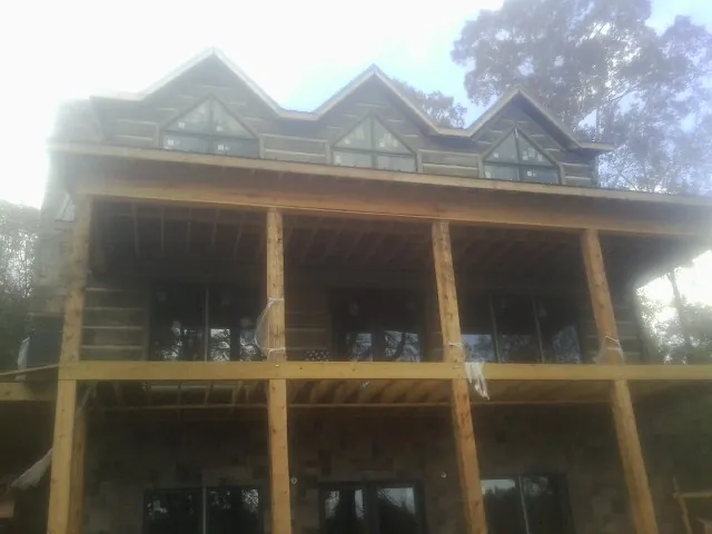 Dormers and porch framing on a large log home under construction — Roof Coating work by our crew in Lutherville Timonium