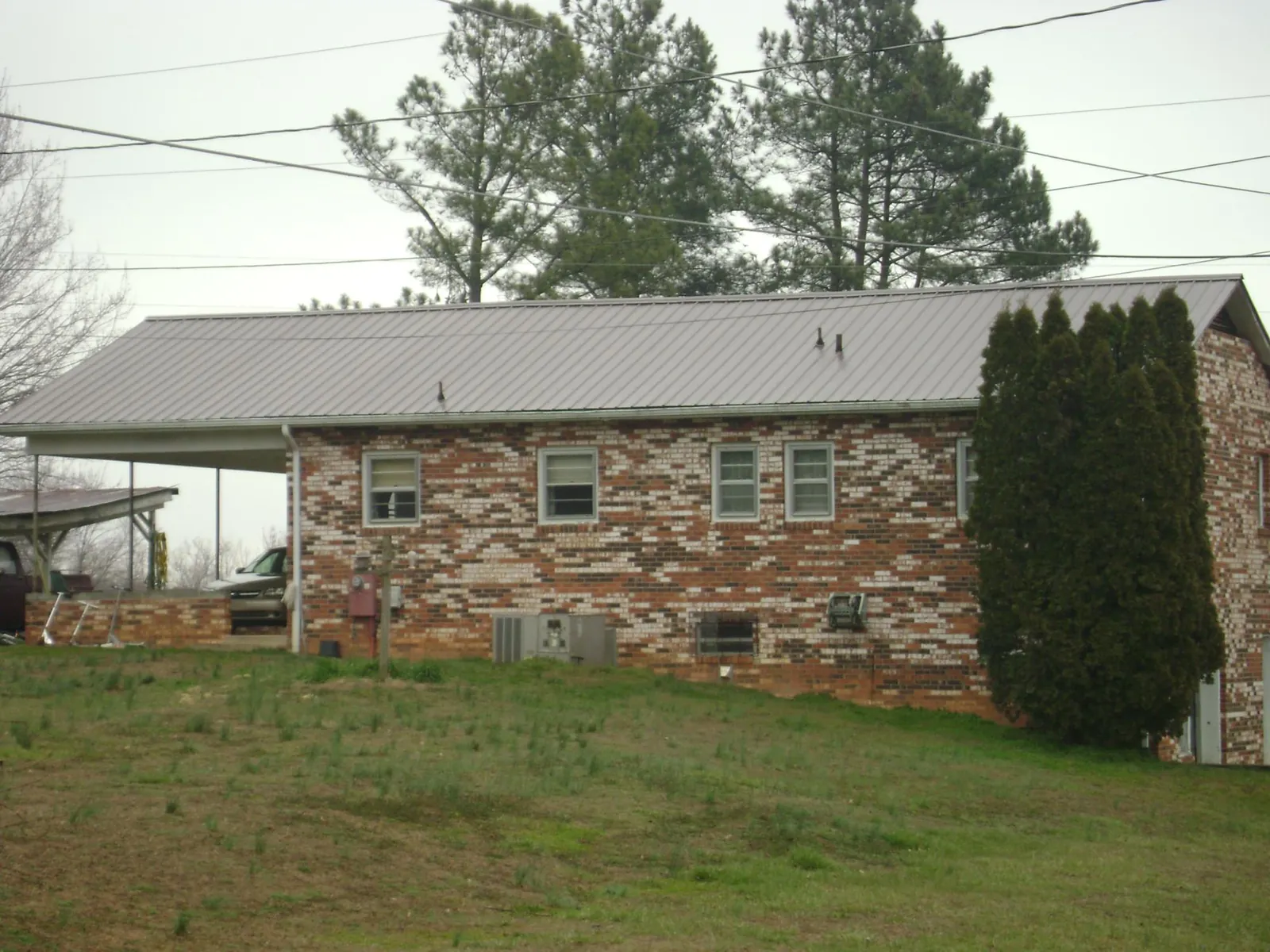 Gray metal roof on a brick split level home with a carport in Lutherville Timonium