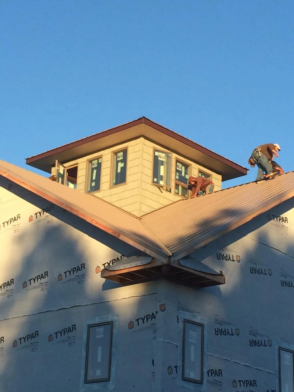 Roofers working around a rooftop cupola on a new metal roof at sunset — Roof Waterproofing in Lutherville Timonium by Roofing Brothers